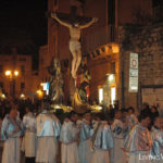 A group of people standing in front of an Easter cross in Italy.