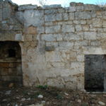 A stone wall with a door in Villa Cappelli, Puglia, Italy.