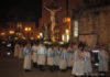 003: Easter in Italy A group of people in white robes celebrating Easter in Italy, standing in front of a statue of Jesus.