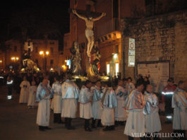 003: Easter in Italy A group of people in white robes celebrating Easter in Italy, standing in front of a statue of Jesus.