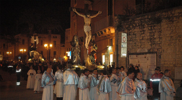 003: Easter in Italy A group of people in white robes celebrating Easter in Italy, standing in front of a statue of Jesus.