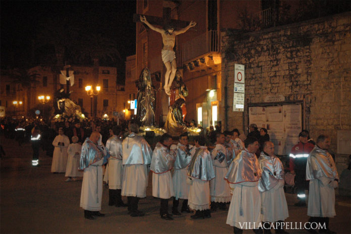 003: Easter in Italy A group of people in white robes celebrating Easter in Italy, standing in front of a statue of Jesus.