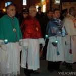 A festive group of priests wearing robes during Easter in Italy.