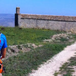 A man on an Italian bike tour riding down a dirt road.