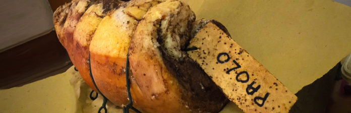 011: Prosciutto, pancetta, and sausage from Tuscany A piece of bread with a label on it and pancetta