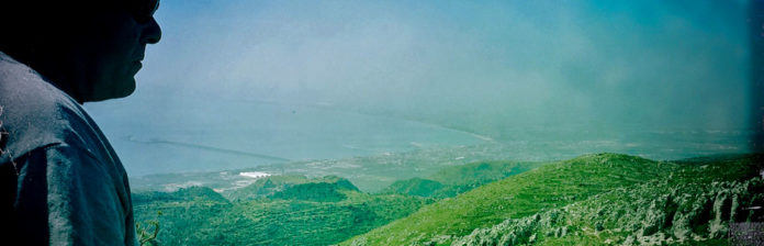 008: Travel with us to the Gargano A man gazing out of a window at a majestic mountain in Gargano.