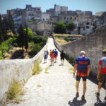 A group of people on an Italian bike tour biking down a stone path.