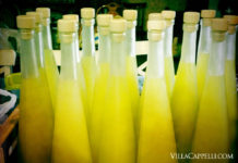 Villa Cappelli Limoncello A collection of bottles containing yellow liquid, inviting you to travel and explore the scenic Gargano region with us.