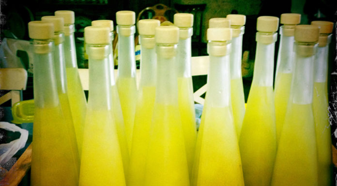 Villa Cappelli Limoncello A collection of bottles containing yellow liquid, inviting you to travel and explore the scenic Gargano region with us.