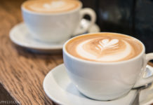 Italian Travel Tip: Cappuccino Two Italian cappuccinos on a wooden table.
