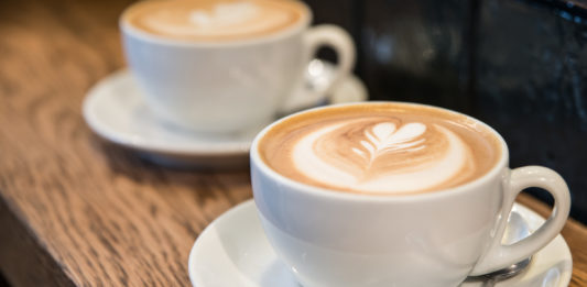 Italian Travel Tip: Cappuccino Two Italian cappuccinos on a wooden table.