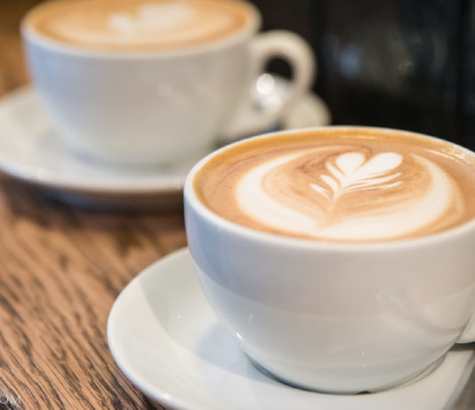 Italian Travel Tip: Cappuccino Two Italian cappuccinos on a wooden table.