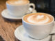 Italian Travel Tip: Cappuccino Two Italian cappuccinos on a wooden table.