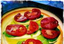 Villa Cappelli Caprese A Villa Cappelli Caprese plate with tomatoes and lettuce on a table.