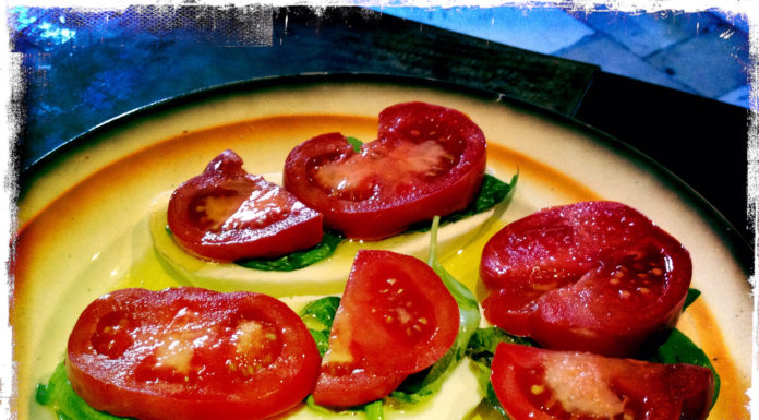 Villa Cappelli Caprese A Villa Cappelli Caprese plate with tomatoes and lettuce on a table.