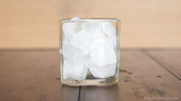 Italian Travel Tip: Enjoy a refreshing glass of ice-cold water on a wooden table.