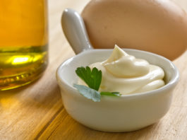 Extra Virgin Olive Oil Mayo A bowl of sour cream and MAYO on a wooden table.