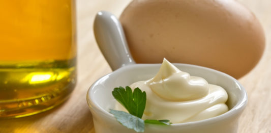 Extra Virgin Olive Oil Mayo A bowl of sour cream and MAYO on a wooden table.