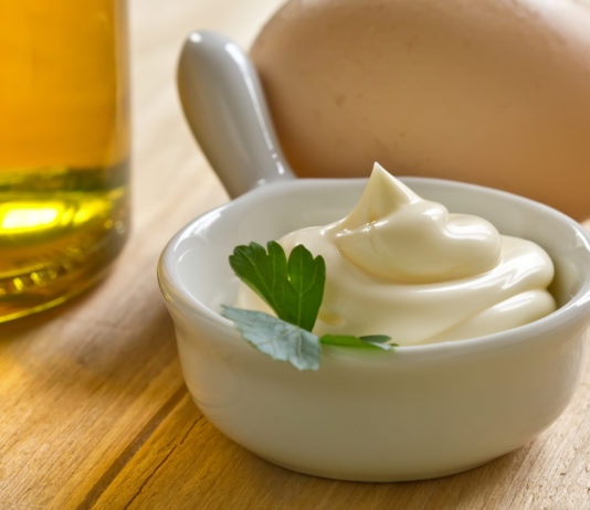 Extra Virgin Olive Oil Mayo A bowl of sour cream and MAYO on a wooden table.